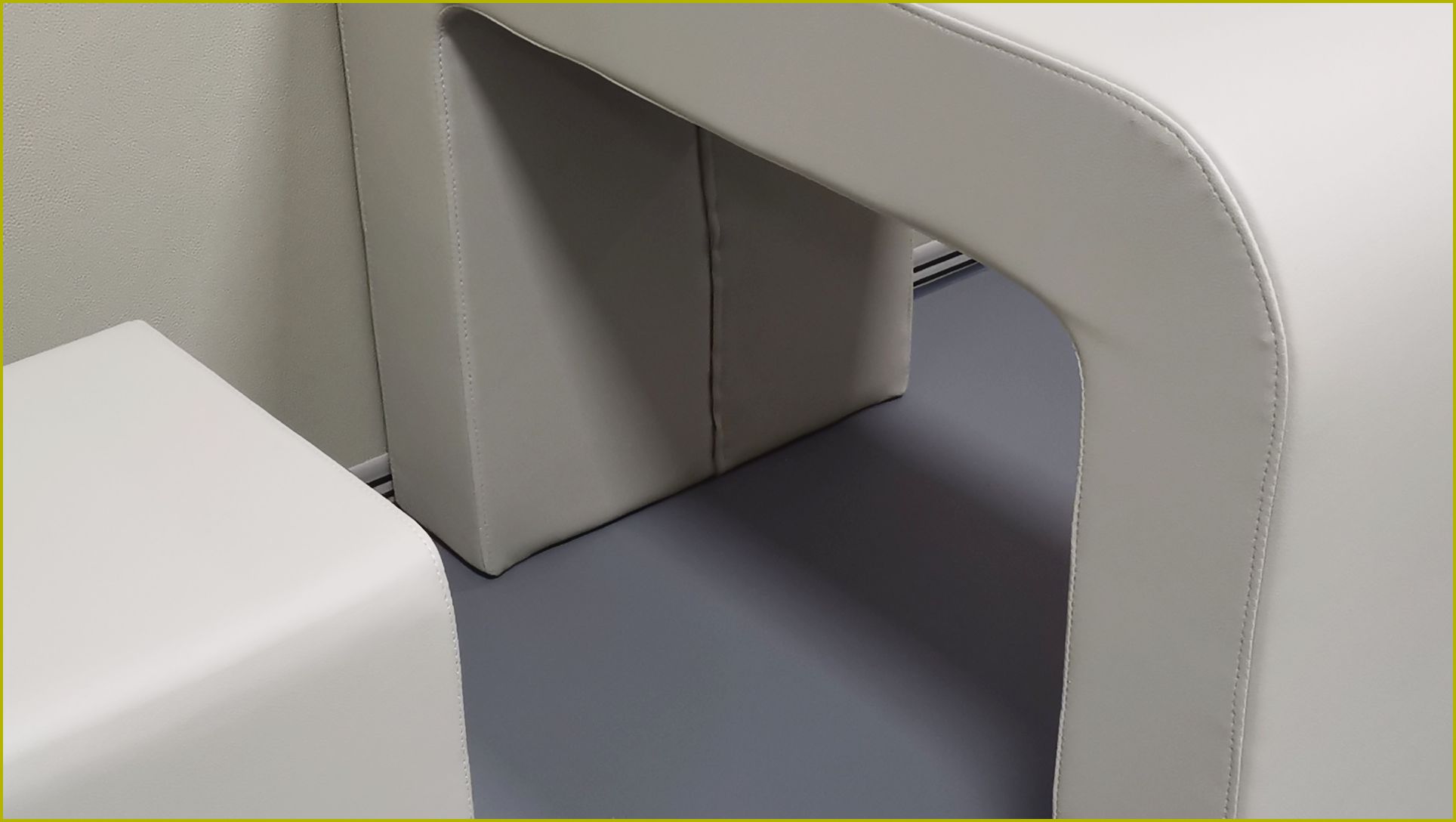 白色皮革软包防撞桌特写，圆角缝线工艺高密度海绵填充，适用于办案区审讯室防撞